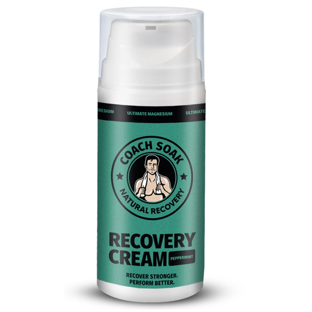 A bottle of Coach Soak Recovery Cream - Magnesium Rich Lotion with peppermint scent, designed to help with muscle tension and post-workout recovery, featuring an illustration of a coach or trainer figure on the label.