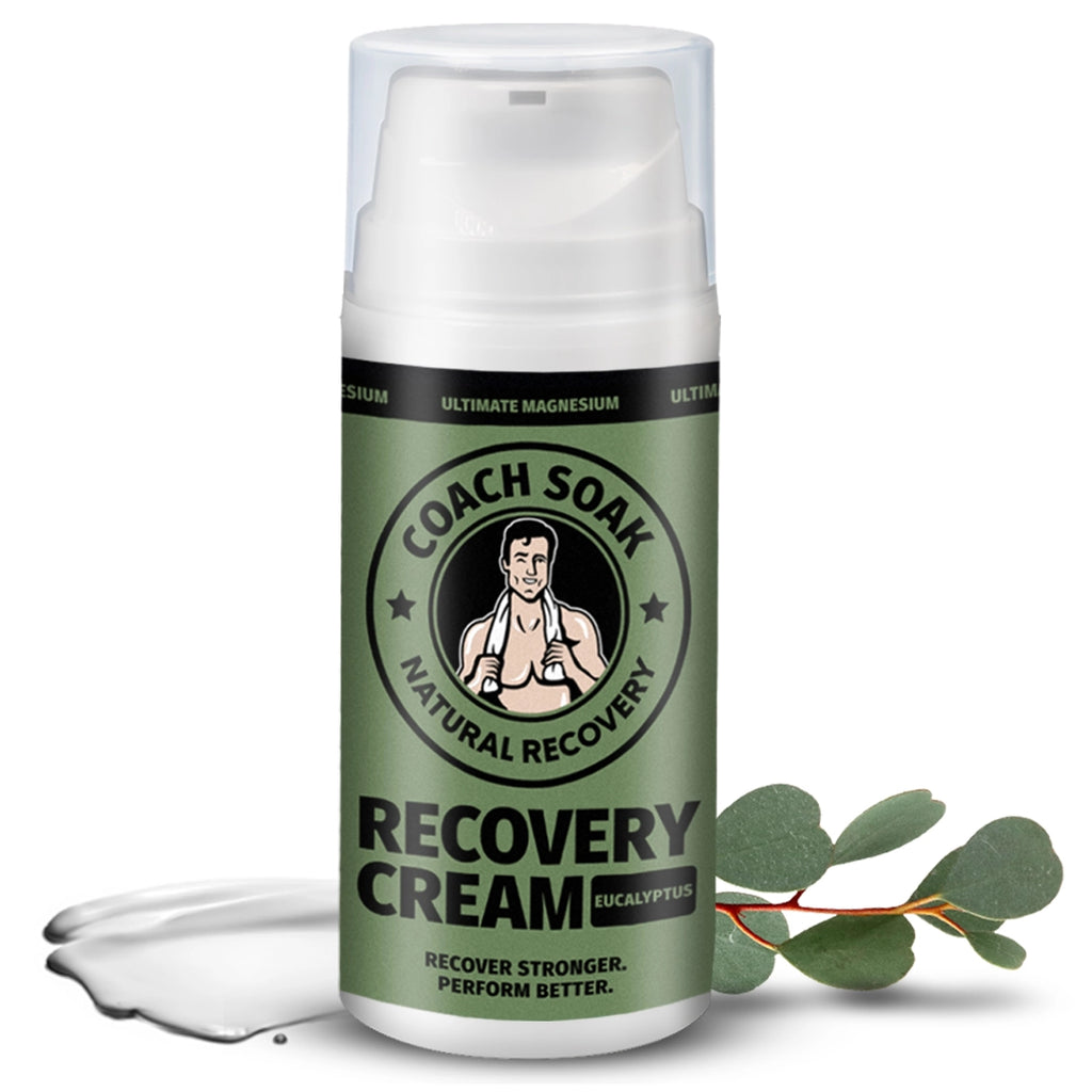 A bottle of Coach Soak Recovery Cream - Magnesium Rich Lotion with eucalyptus for natural post-workout recovery, positioned next to a sprig of eucalyptus leaves, possibly to underline.